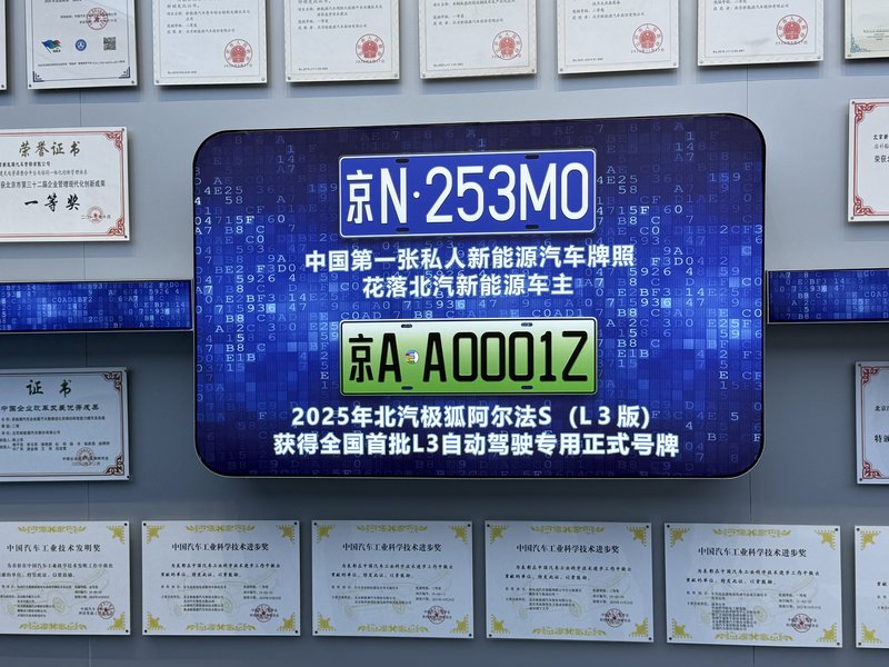 Οι δύο πινακίδες που εκτίθενται στα κεντρικά της BAIC έχουν ιδιαίτερη σημασία. Η επάνω αφορά την πρώτη ιδιωτική πινακίδα οχήματος νέας ενέργειας στην Κίνα, ενώ η κάτω μία από τις πρώτες επίσημες πινακίδες για αυτόνομη οδήγηση επιπέδου L3.