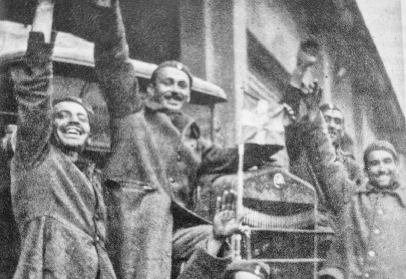 Οπλίτες σε στιγμή χαλάρωσης μπροστά σε αυτοκίνητο. Τα αυτοκίνητα δεν έφταναν παντού,  αλλά εξασφάλισαν, σε συνεργασία με τον σιδηρόδρομο τις μετακινήσεις και τον εφοδιασμό, αλλά και τη μεταφορά τραυματιών προς και από τη γραμμή των πρόσω, εγκαθιστάμενα στο συλλογικό φαντασιακό.