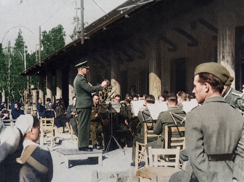 Πρωί Κυριακής στην «Αίγλη» του Ζαππείου. Παίζει η μπάντα των Γερμανών μπροστά σε άδεια καθίσματα. Παρακολουθούν μόνο λίγες Γερμανίδες νοσοκόμες.